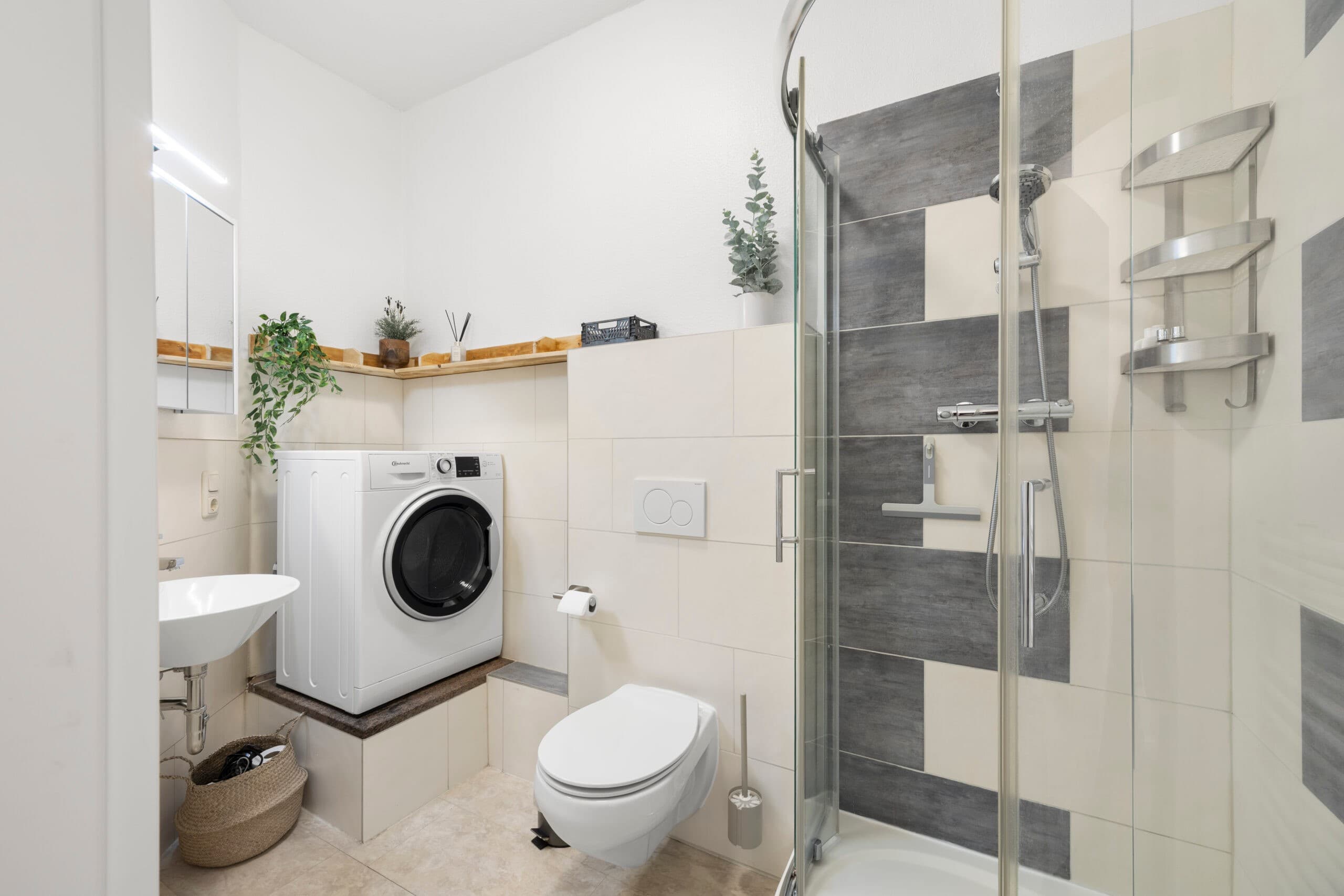 Badezimmer mit Glasdusche und hellen Fliesen