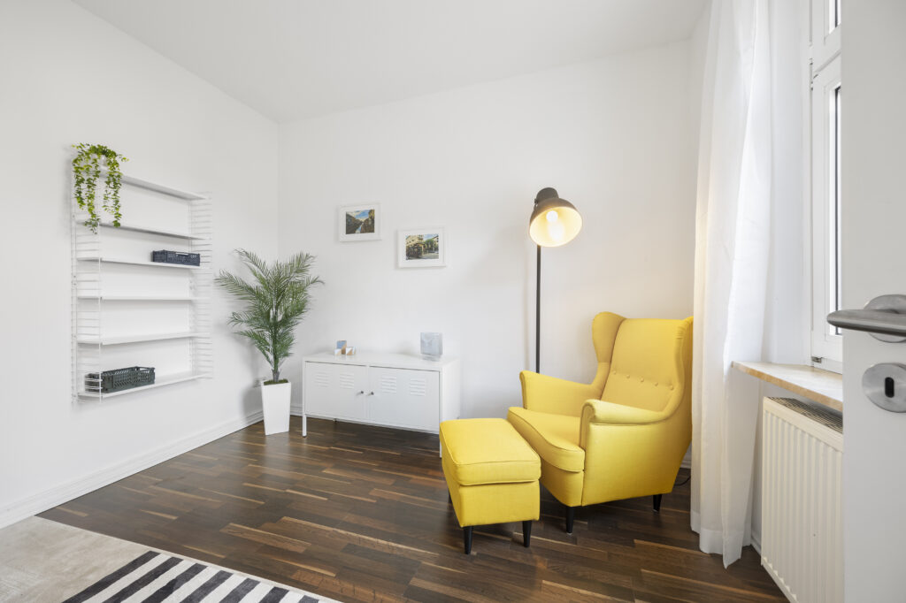 Heller Wohnbereich mit offenem Regal, Pflanzen und Blick durch Tür in stilvolle Altbauwohnung in Lüneburg